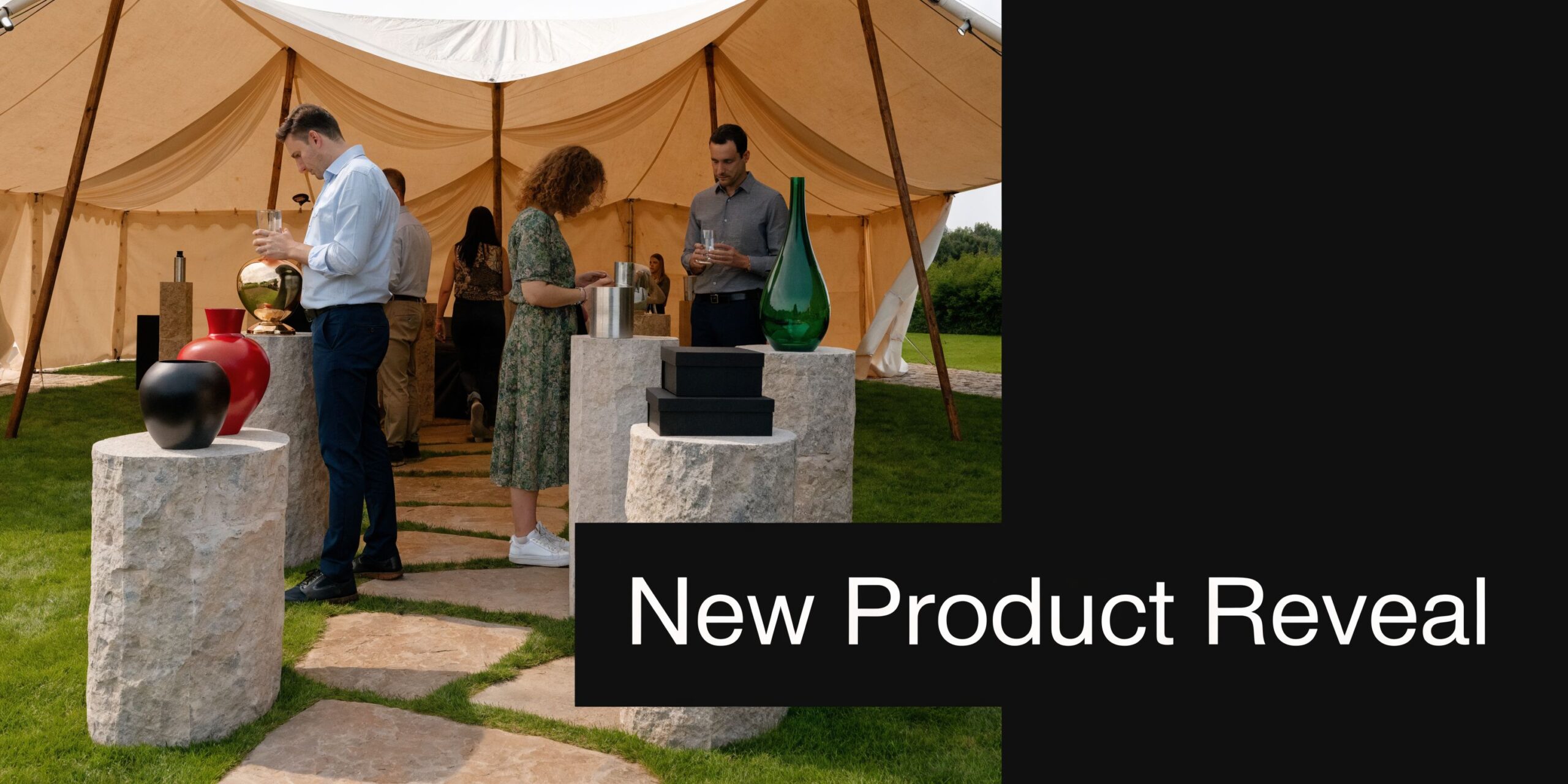 People attending an elegant outdoor product launch event under a large white marquee on a grassy lawn.