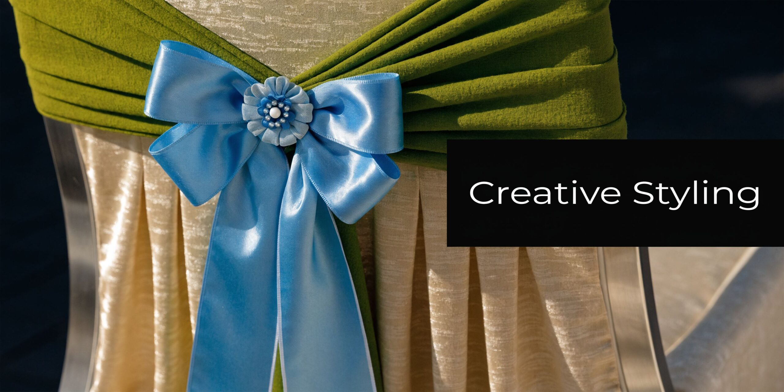 A close-up of a decorative chair cover featuring green fabric draped with a blue satin ribbon bow.