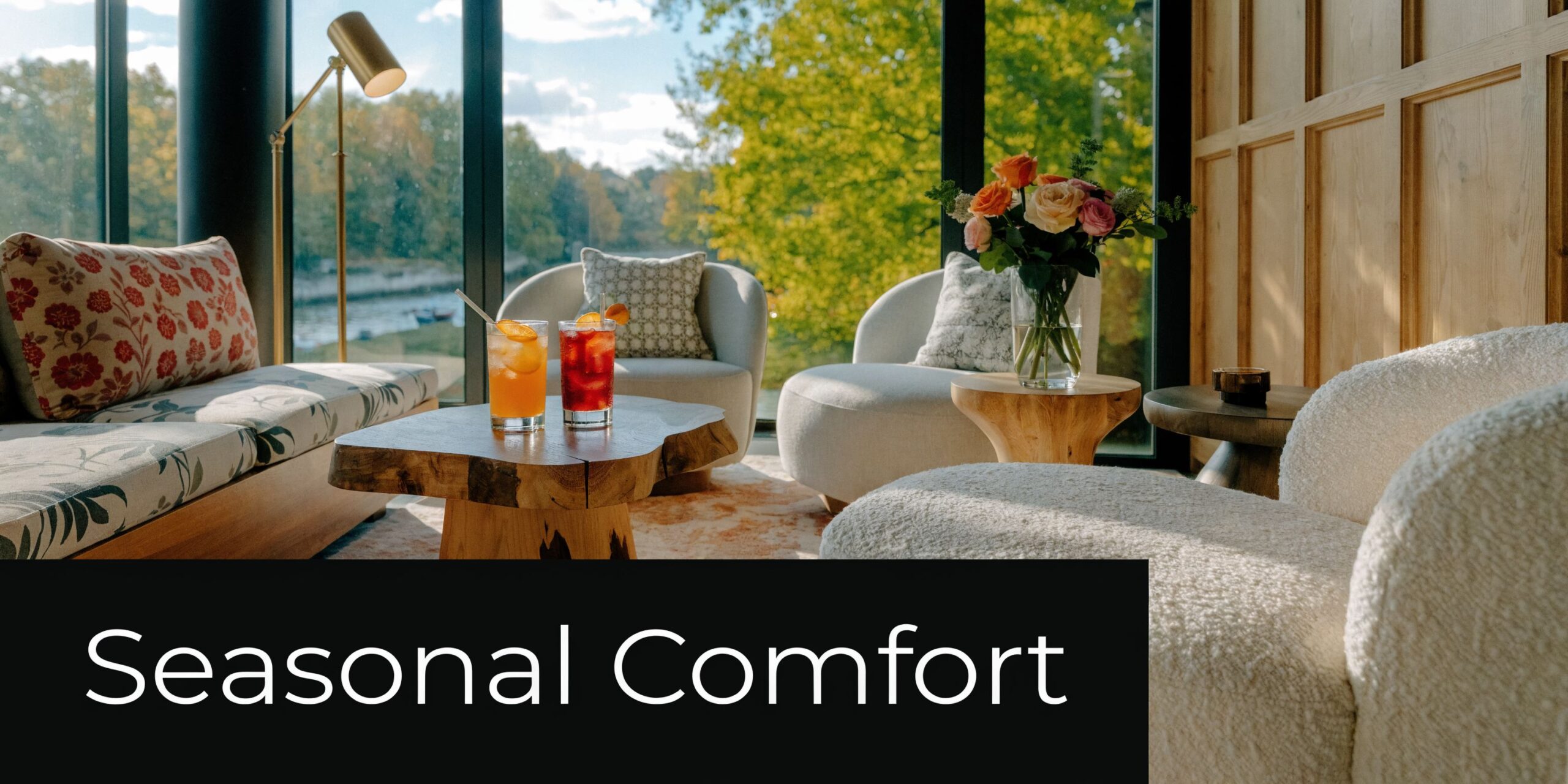 A cozy lounge area featuring comfortable armchairs, a wooden coffee table with drinks, and scenic window views.