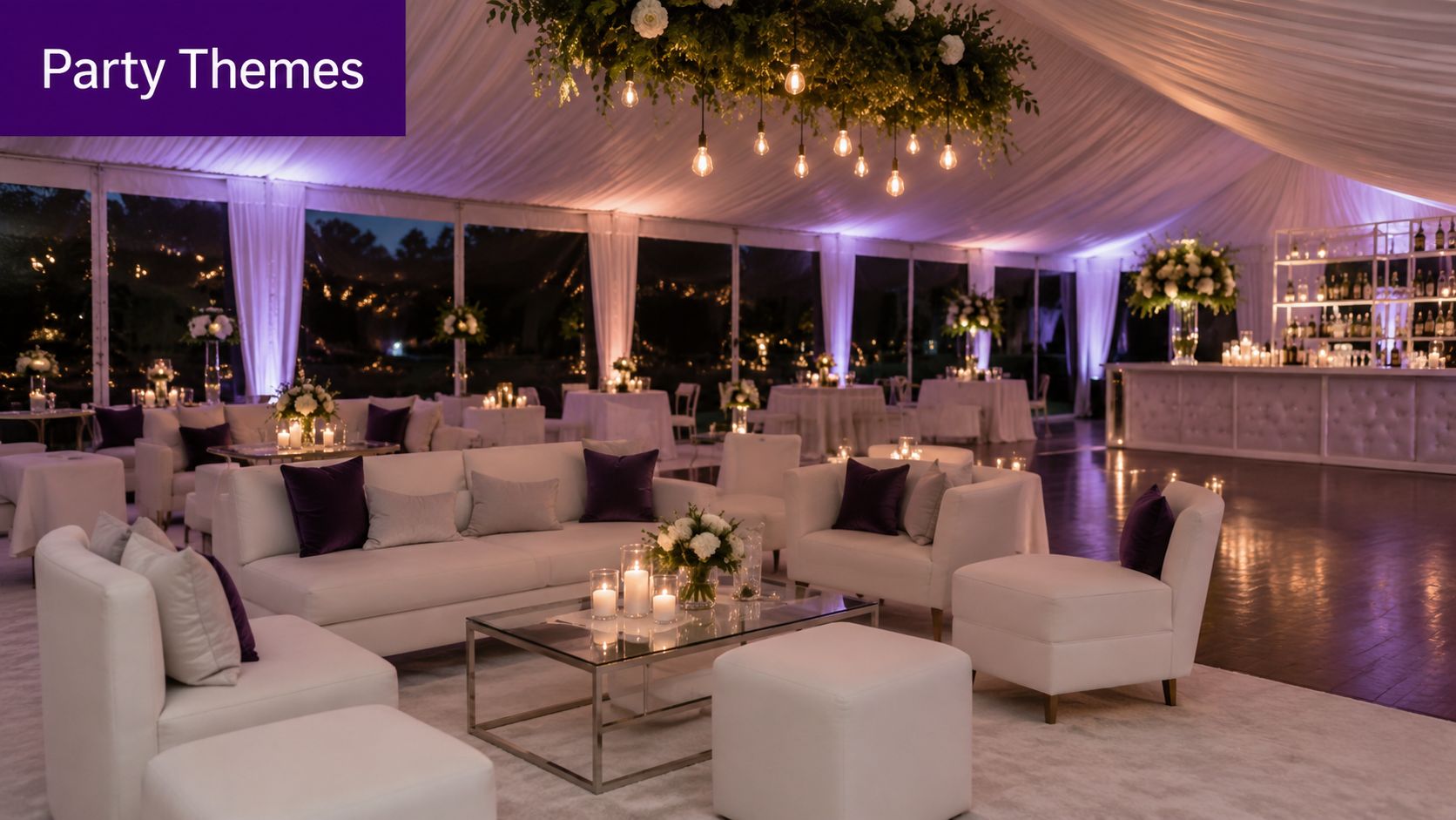 A luxurious outdoor tent setup for an event featuring white sofas, glass tables, and soft lighting.