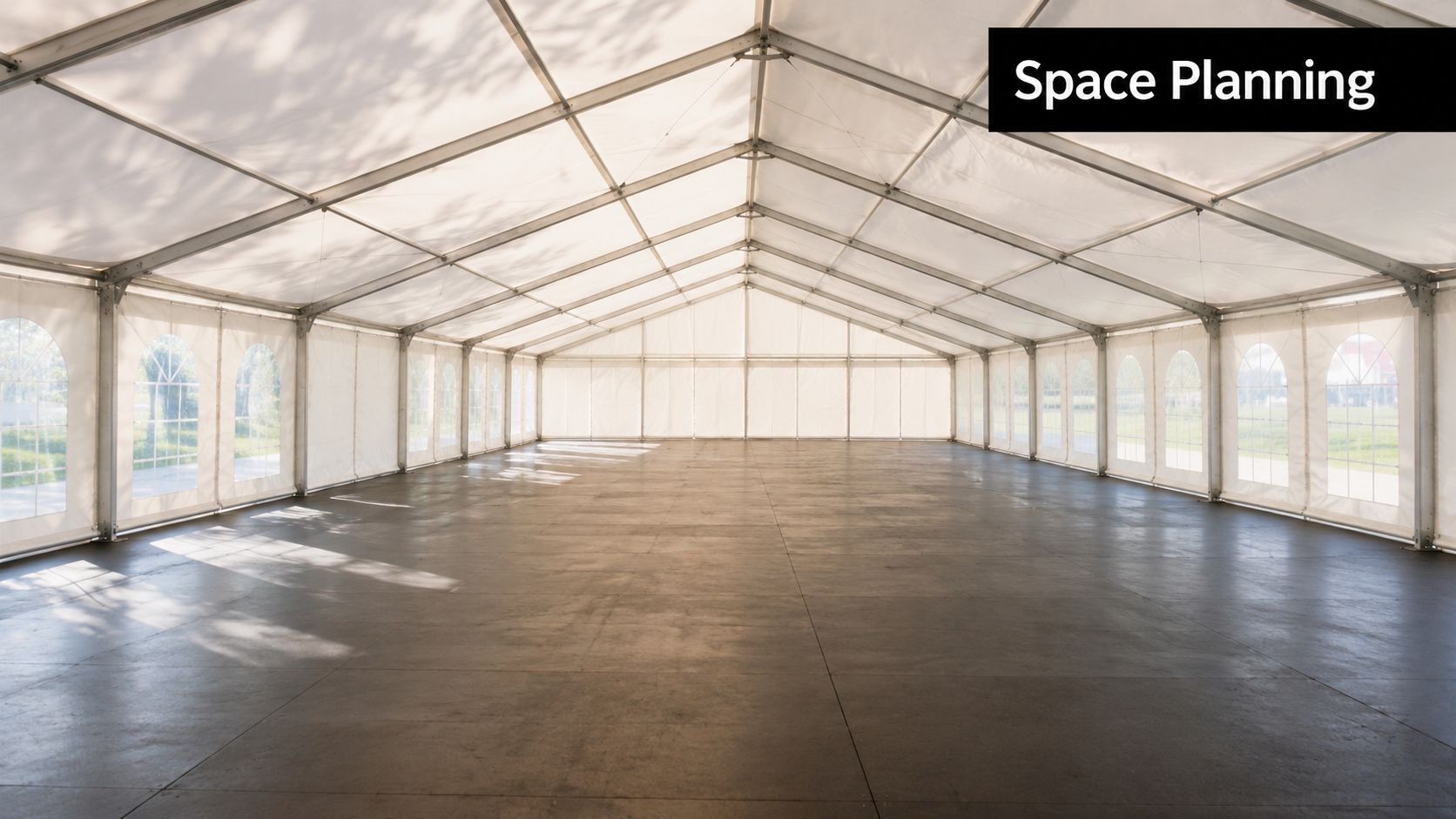 A wide, empty marquee tent with large windows and a clean floor, set up for events.