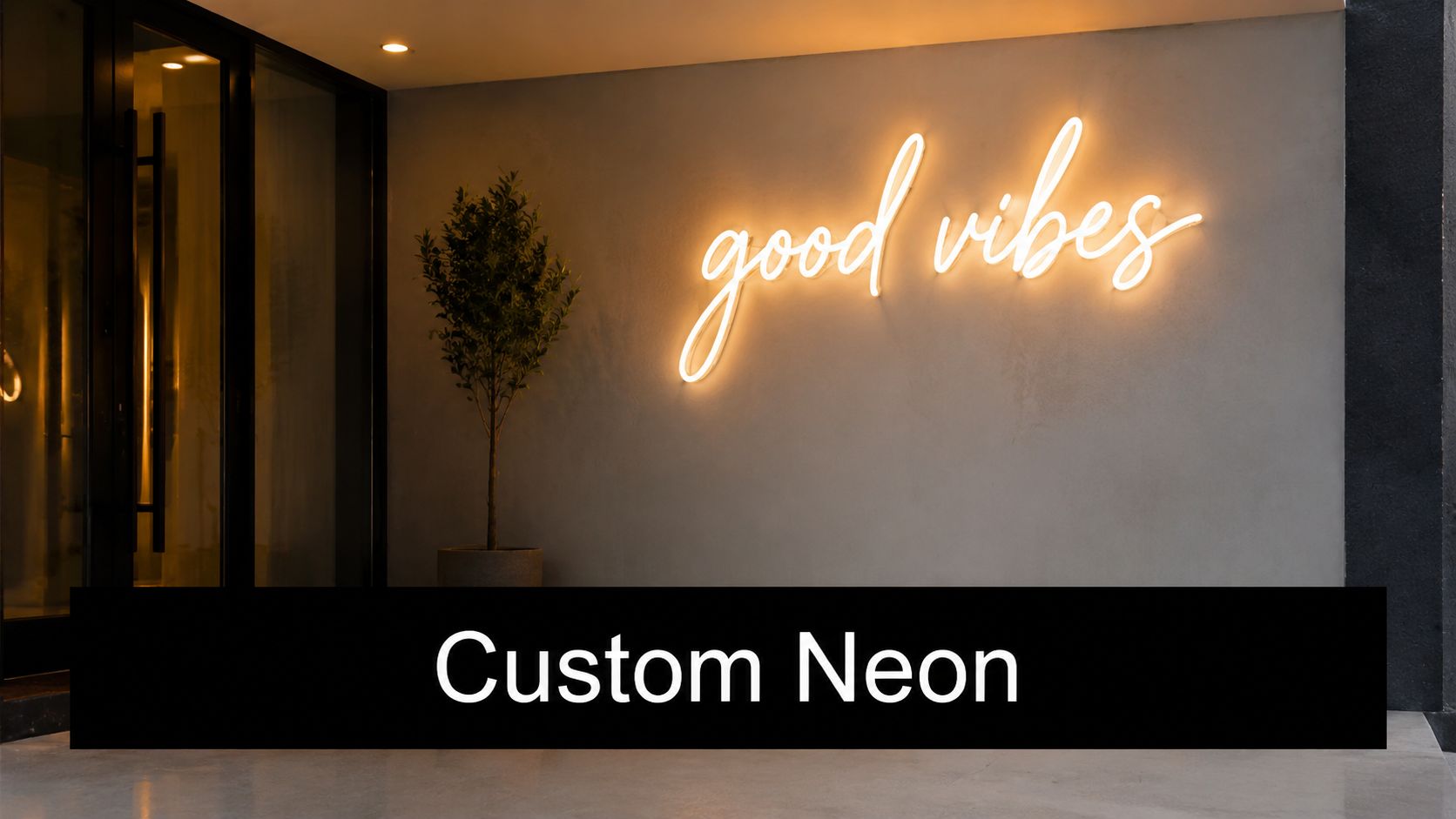 A glowing warm-toned neon sign reading good vibes mounted on a modern grey minimalist wall.